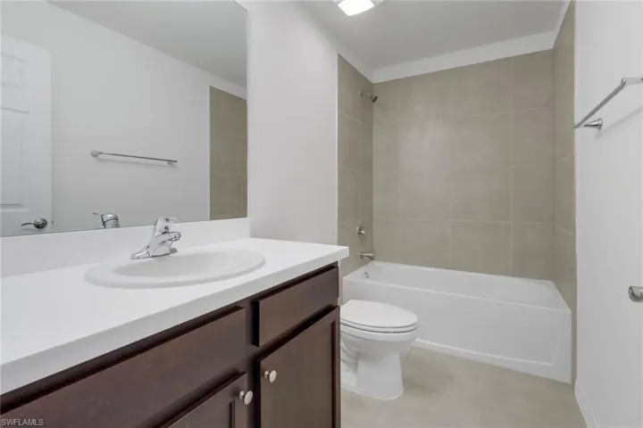 Full bathroom featuring tile patterned floors, vanity, toilet, and tiled shower / bath