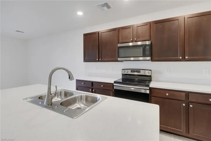 Kitchen featuring sink, dark brown cabinetry, and stainless steel appliances