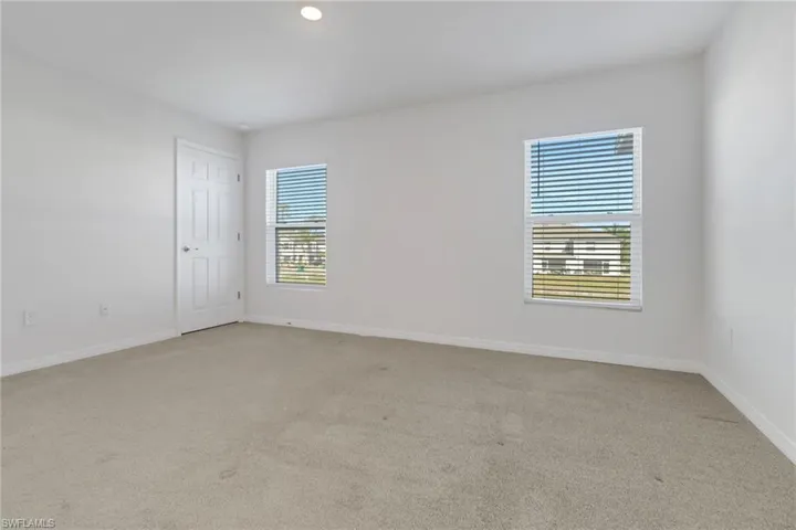 Carpeted bedroom with a wealth of natural light