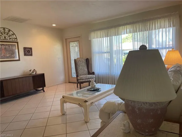 Living room with light tile patterned floors and visible vents