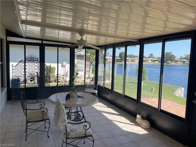 Unfurnished sunroom featuring a water view and ceiling fan