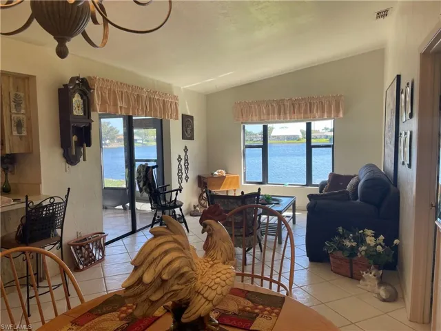 Living room featuring plenty of natural light, vaulted ceiling, and light tile patterned floors
