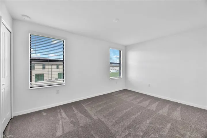 Carpeted empty room featuring baseboards