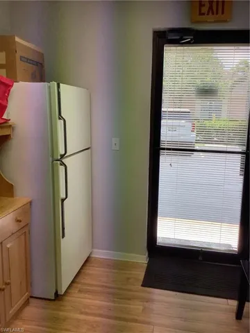 refrigerator and light wood-style flooring