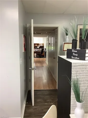 Hallway featuring dark wood-type flooring and an office area