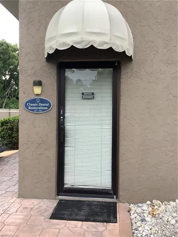 Doorway to property featuring stucco siding