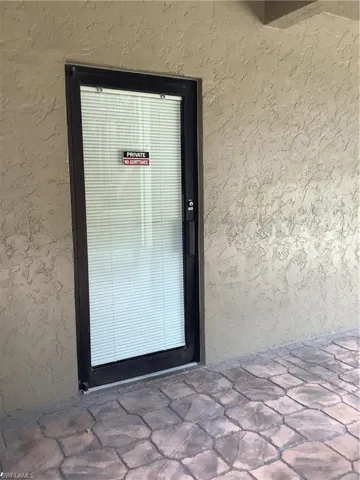 Property entrance featuring stucco siding