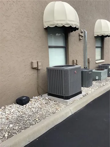 Exterior view of a central air condition unit and stucco siding
