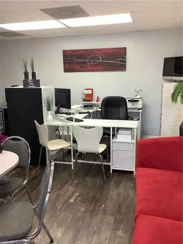 Office space with a drop ceiling and wood finished floors