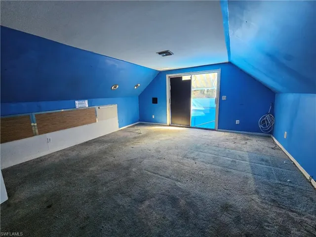 Bonus room with carpet flooring and lofted ceiling