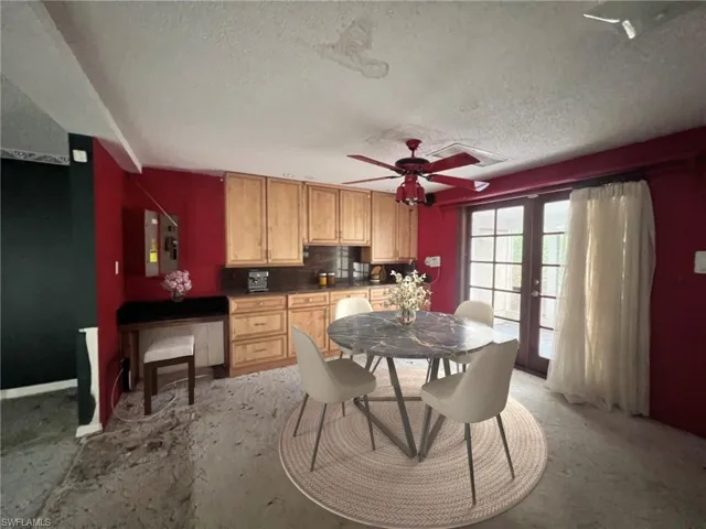 Kitchen featuring electric panel, french doors, ceiling fan, decorative backsplash, and a textured ceiling