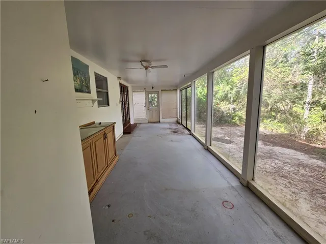 Unfurnished sunroom with ceiling fan