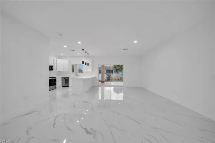 Unfurnished living room featuring recessed lighting and light marble finish floors