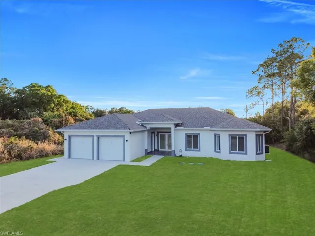Ranch-style home featuring a front yard, a garage, and stucco siding