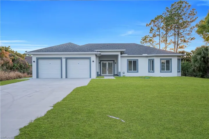 View of front of property with roof with shingles, a front lawn, an attached garage, and concrete driveway