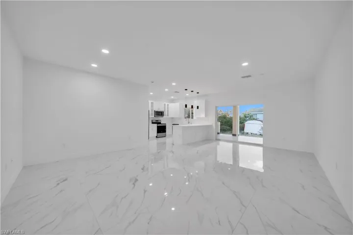 Unfurnished living room with recessed lighting and light marble finish floors