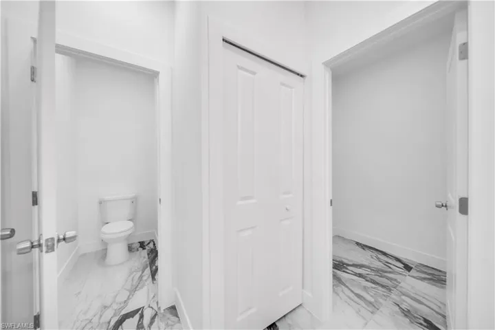 Bathroom with toilet and light marble finish floors