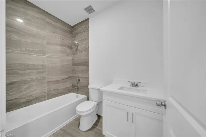 Full bathroom featuring vanity,  shower combination, and light wood-style floors