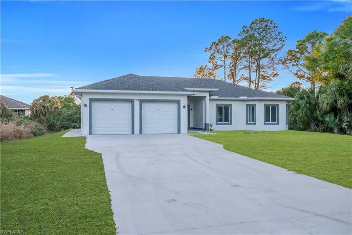 Single story home featuring a front yard, an attached garage, a shingled roof, concrete driveway, and stucco siding