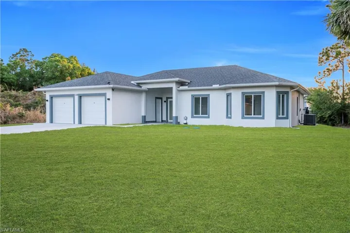 Prairie-style house with a front lawn, a garage, stucco siding, concrete driveway, and roof with shingles