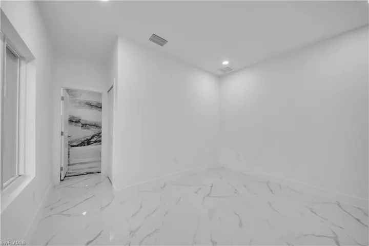 Spare room featuring light marble finish floors and recessed lighting