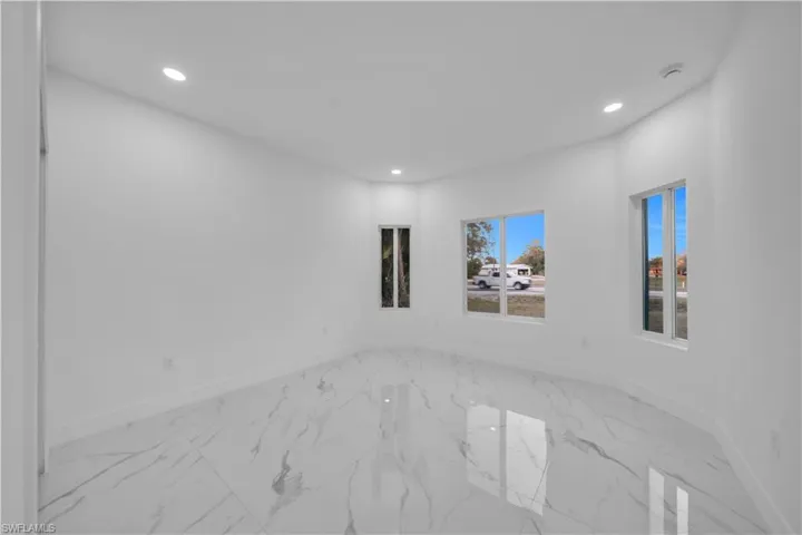 Empty room featuring light marble finish flooring and recessed lighting
