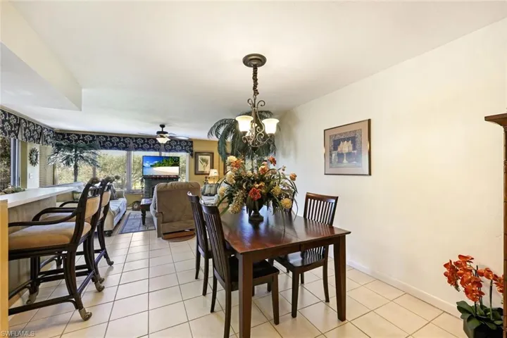 Dining space featuring light tile patterned floors, baseboards, and a chandelier