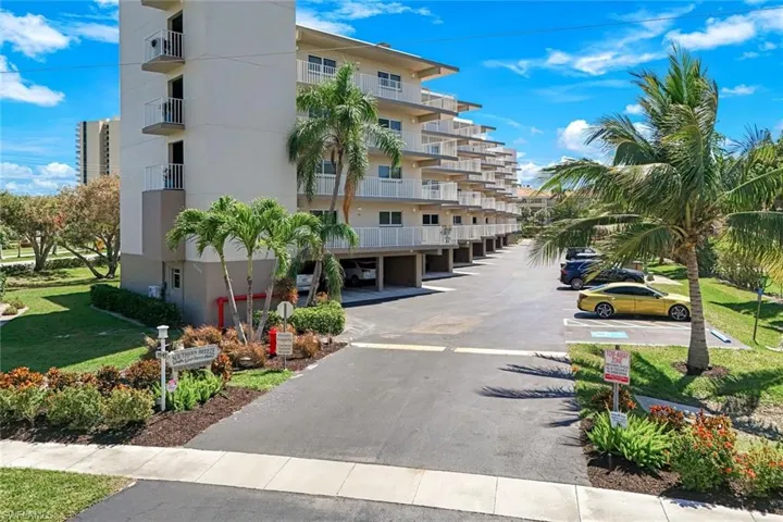 View of building exterior with uncovered parking