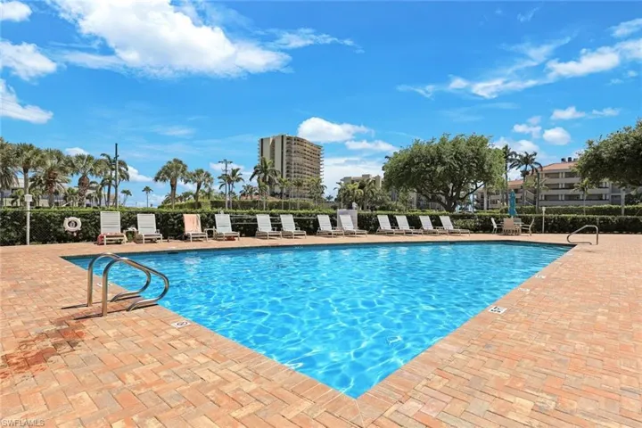 Community pool with a patio and fence