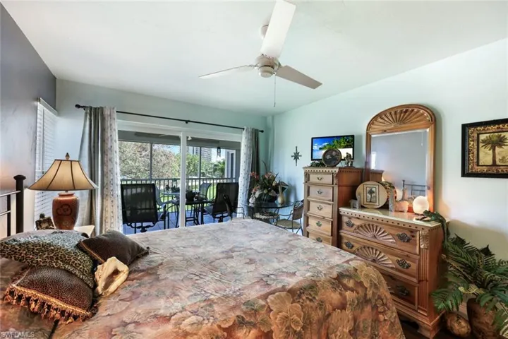 Bedroom with access to exterior, vaulted ceiling, and ceiling fan