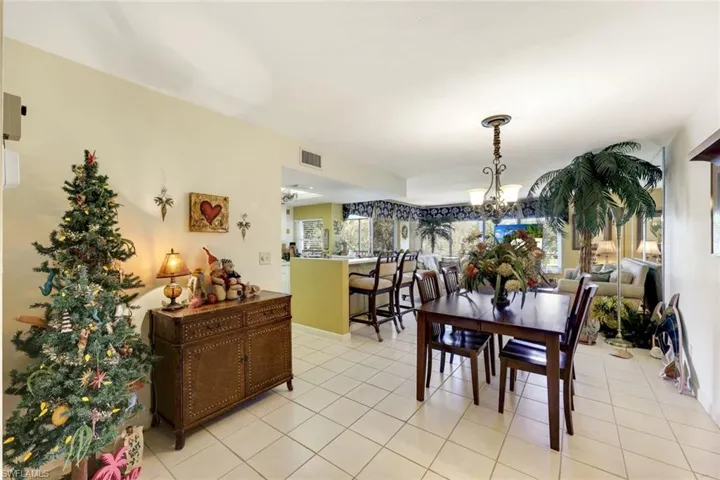 Dining area featuring an inviting chandelier, light tile patterned floors, and visible vents