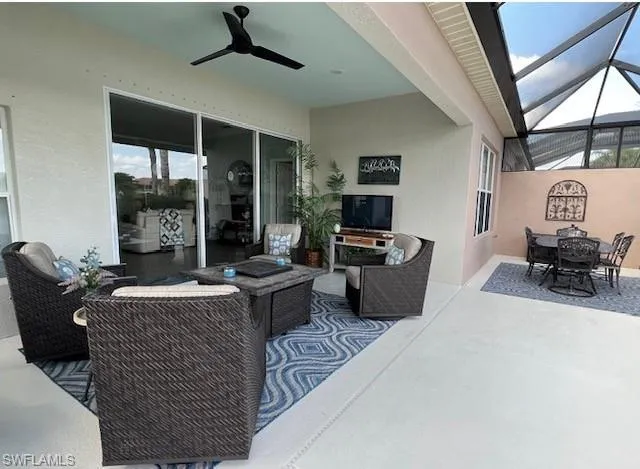 View of patio featuring glass enclosure and ceiling fan