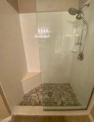 Bathroom with tile patterned flooring and a tile shower