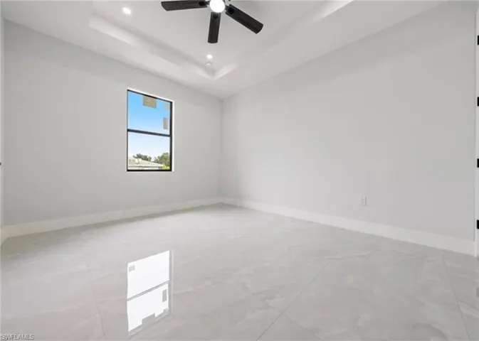 Unfurnished room with recessed lighting, a tray ceiling, and a ceiling fan