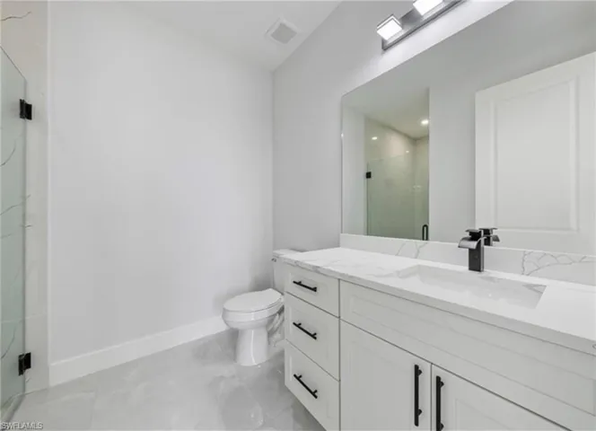 Bathroom featuring a shower stall and vanity