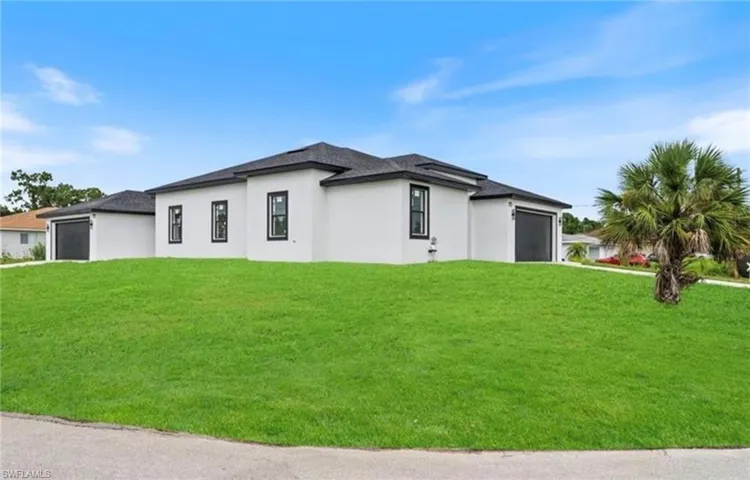 View of property exterior featuring a garage, a yard, and stucco siding