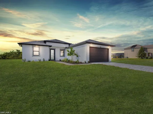 Prairie-style home with a yard, stucco siding, driveway, and a garage