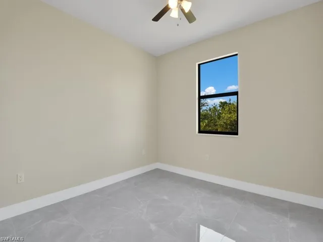 Empty room featuring baseboards and a ceiling fan