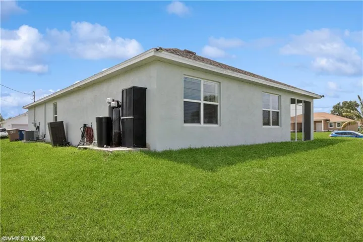 Back of property featuring a yard and central AC