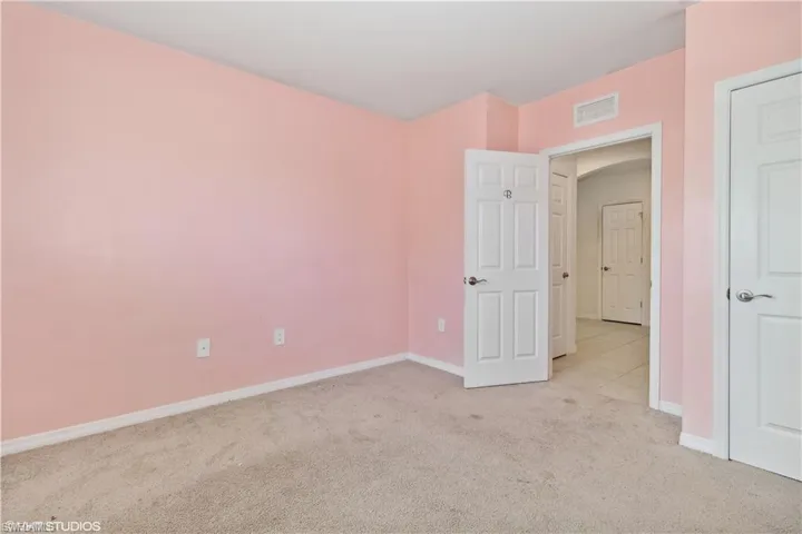 Unfurnished bedroom with light tile flooring