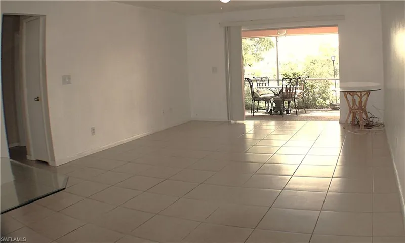 Empty room featuring light tile patterned flooring and baseboards