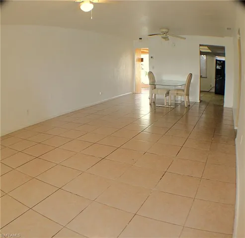 Unfurnished room featuring light tile patterned flooring and ceiling fan