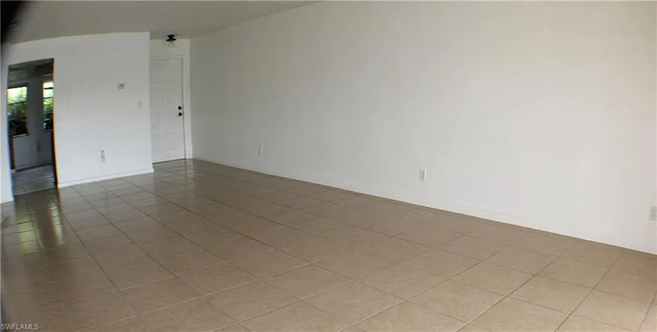 Tiled spare room with arched walkways and baseboards