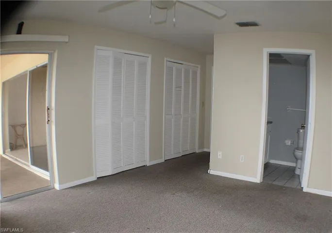 Unfurnished bedroom featuring two closets, carpet, and a ceiling fan