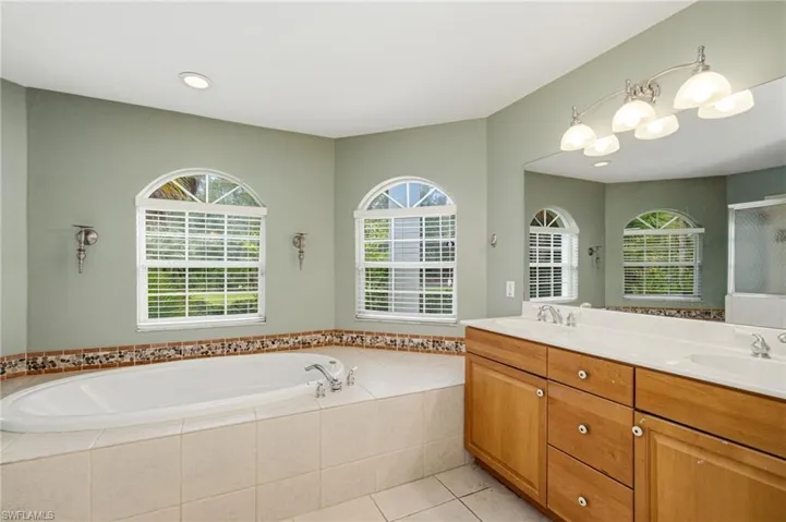 Soaking tub with tile surround and decorative mosaic border