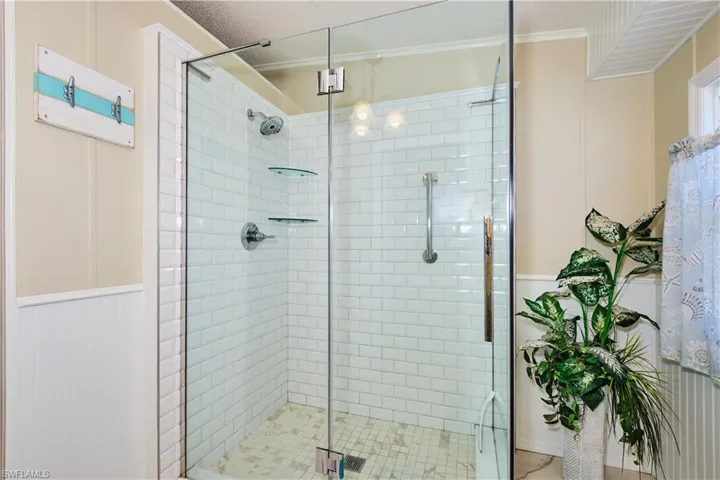Bathroom featuring a textured ceiling and a stall shower