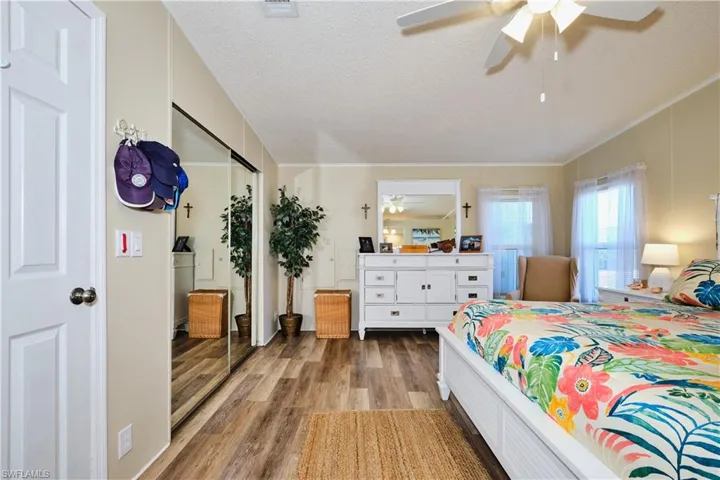 Bedroom featuring a textured ceiling, wood finished floors, and a ceiling fan
