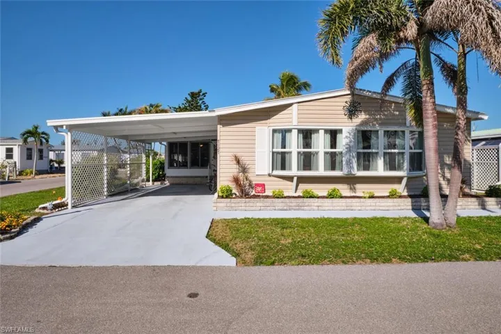 Manufactured / mobile home with an attached carport and concrete driveway