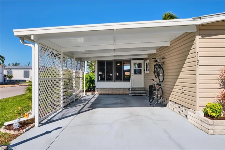 View of patio / terrace with a carport, entry steps, and driveway