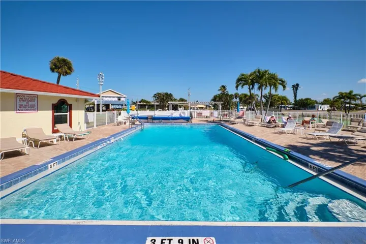 Community pool with a patio and fence